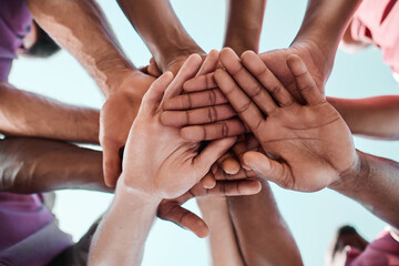 People, teamwork and hands together in collaboration, goals or community for motivation below. Closeup of group piling in team building, solidarity or trust in support for sports, rugby or match