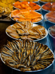 grilled fish in white serving dishes or plates on display, closeup