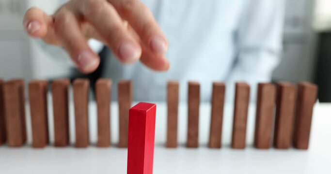 Female hand selects red block from row of beige wooden blocks. Self-determination of personality and how to find your profession