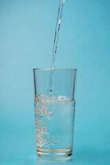 a glass of clear water on a blue background