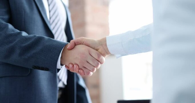 Businessman in business suit is shaking hands with partner. Business arrangement concept