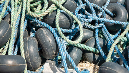 Close-up of tangled fishing net and buoys  on the quayside