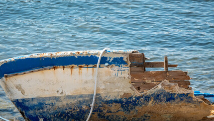 A shattered wooden boat by the sea on the beach