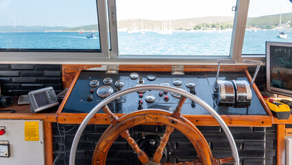 Steering wheel in the captain cabin of a big tour boat or ferry. Inside the captain's cabin....