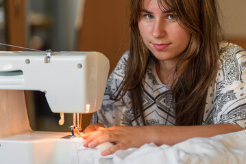 Woman use sewing machine needle Close up tailor Tailoring Process working Caucasian girl Dressmaker...
