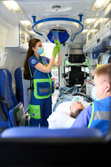 Female doctor puts an IV on patient in an ambulance © Svitlana