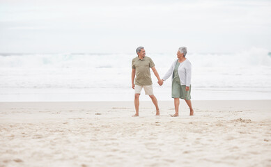 Senior, couple and hand holding on the beach for retirement vacation, holiday or adventure in summer. Elderly, man and woman for walking by ocean or sea with journey and happiness for relax and love