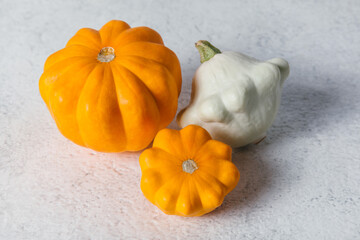 Autumn composition for Thanksgiving Day with variety of pattypan squashes on white kitchen table.