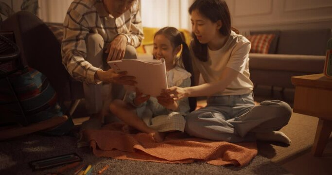 아늑한 아파트에서 엄마와 아빠에게 직접 그린 그림을 보여주는 딸과 자랑스러워하는 부모
