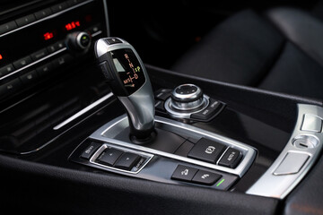Automatic gearbox handle, multimedia dashboard and leather interior of high-end modern car. Close...