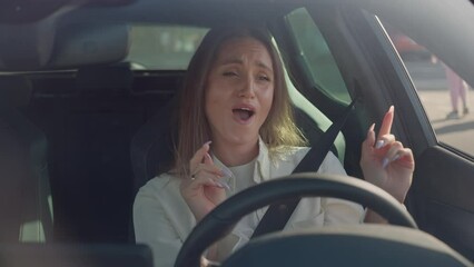 Woman listening and singing song while driving modern car