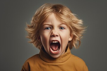 A young boy with his mouth open wide in surprise or excitement. This image can be used to depict astonishment, curiosity, or amazement. - obrazy, fototapety, plakaty
