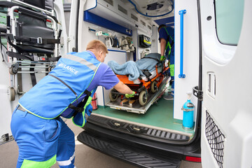 Loading a stretcher with a patient into a modern ambulance