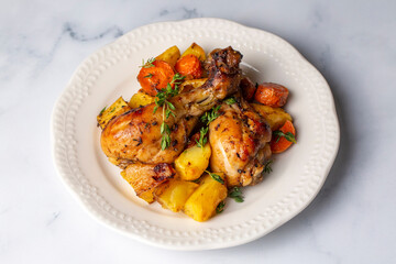 Baked chicken thighs and fried potatoes look delicious.
