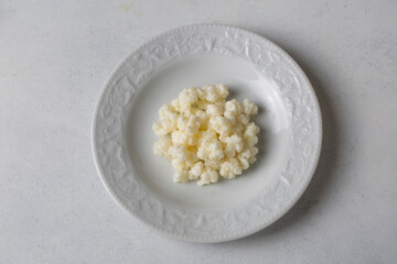 Kefir fermented milk drink with kefir grains. Homemade kefir stands in a glass, next to kefir grains and milk