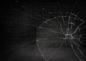 Broken glass as spider web or as bullet hole in the door photography, black and white isolated background