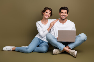 Full length photo of cute pretty married couple wear white shirts typing modern gadget empty space isolated brown color background