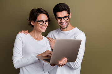 Photo of cheerful cute married couple wear white shirts spectacles online orders device empty space isolated brown color background
