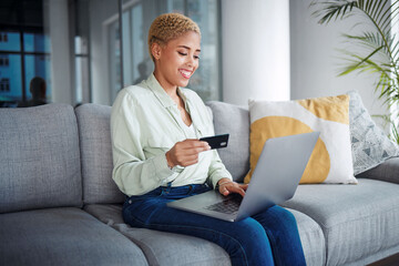 Woman, laptop and credit card for home online shopping, fintech payment and e commerce on her sofa. African person on computer for internet banking, website subscription or application for loan