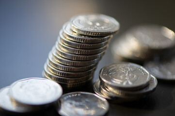 Silver piles of coins on a dark background.