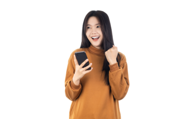 Portrait of a smiling casual Asian woman looking copy space and holding smartphone with fists raised isolated on white background with clipping path.