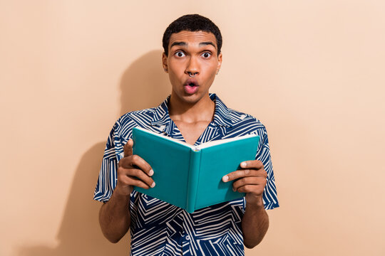 Photo of shocked funky guy dressed print shirt enjoying interesting book isolated beige color background