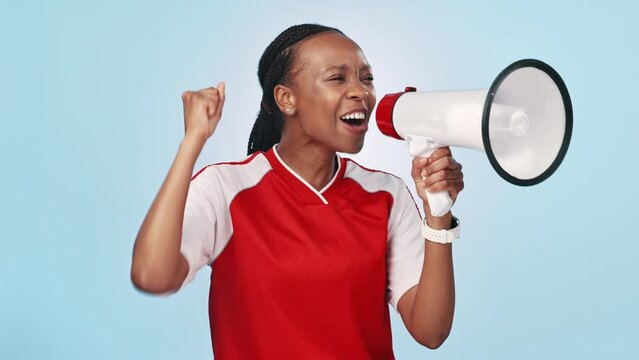 Shout, megaphone and woman athlete in studio for announcement at a sports game or match. Fitness, bullhorn and happy young African female soccer player screaming at tournament by blue background.