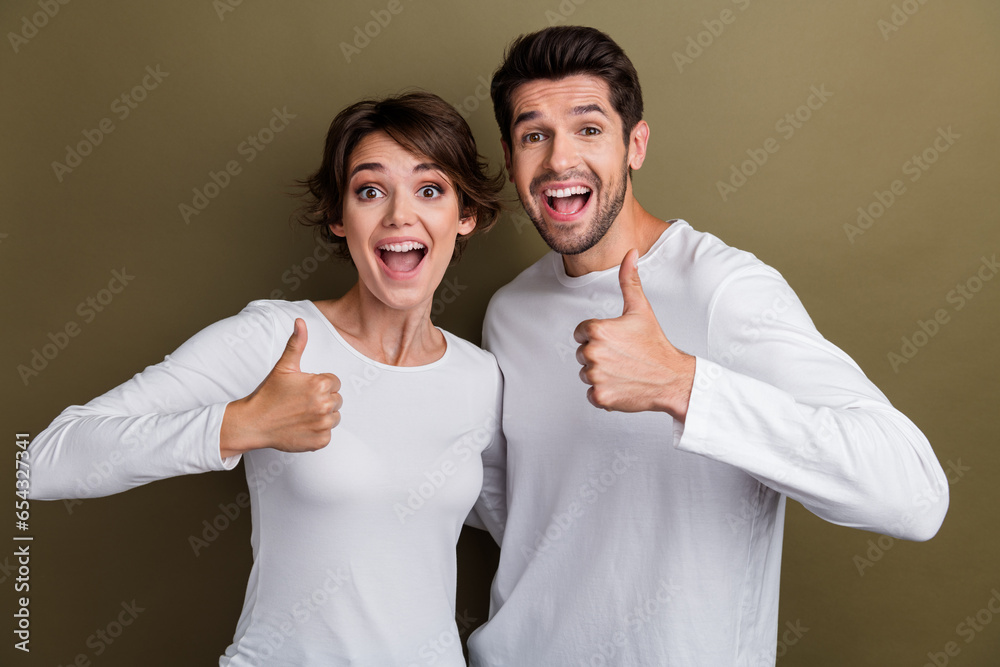 Sticker photo of surprised excited positive friends wear trendy white clothes demonstrate thumb up cool offe