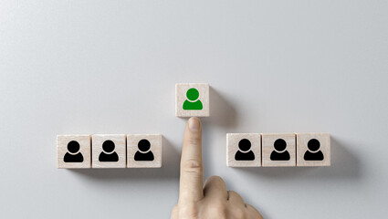 choosing right person. hand selects cube with person highlighted in green. Human resources management and recruitment business hiring concept, corporate hierarchy, recruiter chooses one leader person - obrazy, fototapety, plakaty