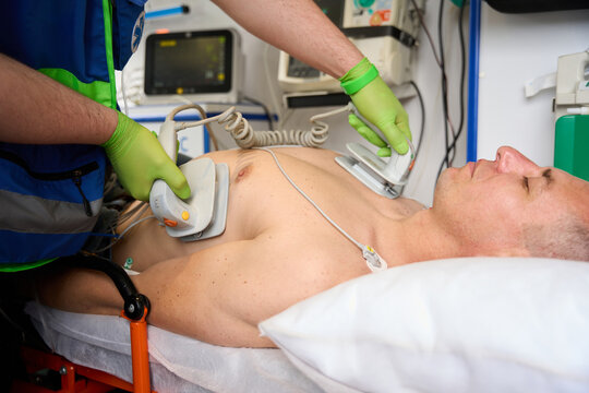 Field team member applies defibrillator electrodes to a patients torso