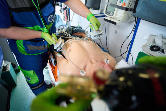 Fellow paramedics resuscitate an injured man in an ambulance