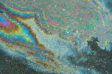 Colored oil stains close up, the color of the gasoline stain on the pavement road as a texture or...