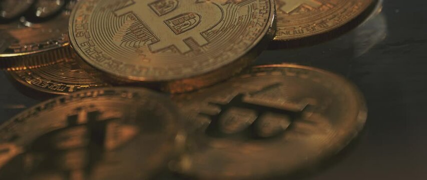 Golden Bitcoin on blur background with beautiful lighting under the glass. Extreme close-up