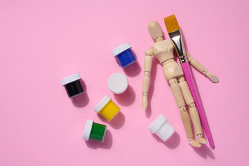 Plastic jars with multi-colored gouache on a pink background, copy space