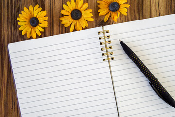 black pen on open lined blank note pad mock up with yellow flowers