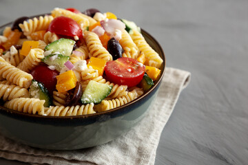 Homemade Organic Greek Pasta Salad in a Bowl, side view. Space for text.