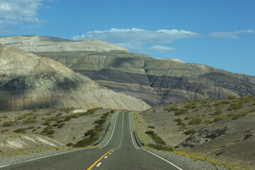 Mountain Majesty: Scenic View of a Winding Paved Road Amidst Majestic Peaks in a Captivating Landscape Photograph