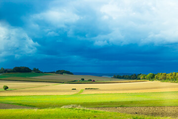 green field and blue sky with clouds