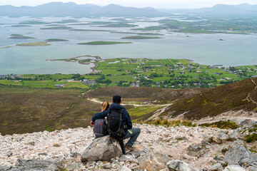 Couple enjoying view on a path to the top of Croagh Patrick mountain. County Mayo, Ireland. Popular...