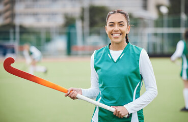 Female, person and happy for hockey with stick in hand on field for training in portrait. Girl, hold and smile with confidence for sports with pose, stand and equipment for match, game or fitness - Powered by Adobe