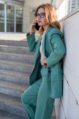 Business woman standing on stairs outside office building while talking on cellphone