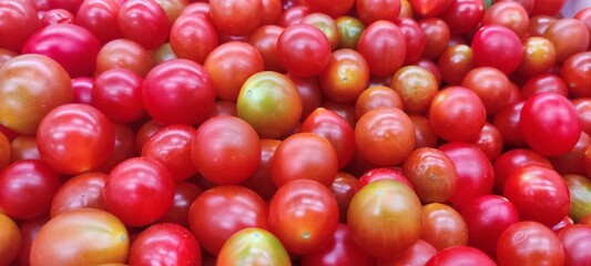 Tomatoes lying on a pile on top of each other, tomato texture. Selective focus.