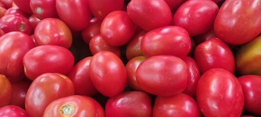 Tomatoes lying on a pile on top of each other, tomato texture. Selective focus.