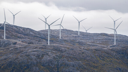 wind engines on the hill from the island of Kvaløya, Norway, with many wind turbines. Windmills on the coast of the Atlantic produce electricity.