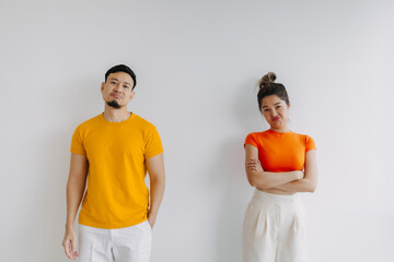 Asian Thai couple wear yellow and orange, standing and getting mad angry, sulking upset isolated on white background.  - obrazy, fototapety, plakaty
