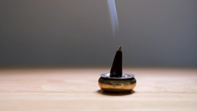 The flames of frankincense that were placed on the black ground had smoke floating in the dark.