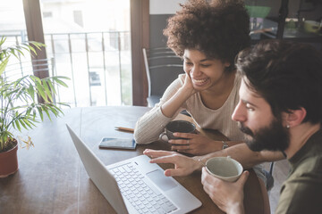 two multiethnic people indoor remote working - obrazy, fototapety, plakaty