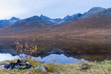 steile Berge auf der Insel Kvaløya, die sich im Wasser des Bergsee spiegeln, in Troms, Norwegen....
