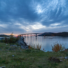 Brücke von Sommarøy nach dem Sonnenuntergang, roter Streifen am Himmel, unter den grau blauen Wolken in Troms, Norwegen. Abendrot im Herbst am Nordatlantik
