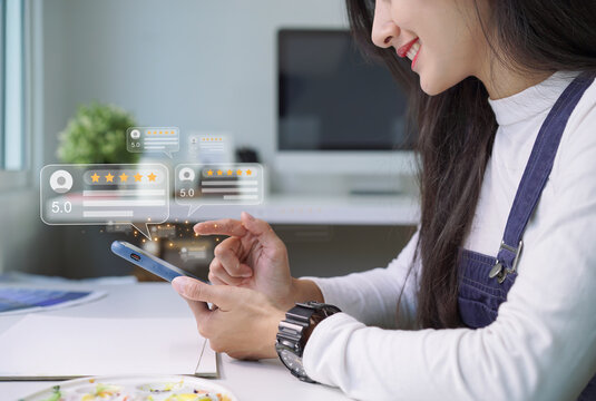 Close Up Of Customer Writing Reviews, Hand Pressing On A Smartphone Screen With A Golden Five Star Rating Feedback Icon. Concept Of Rating And Feedback For Evaluation.